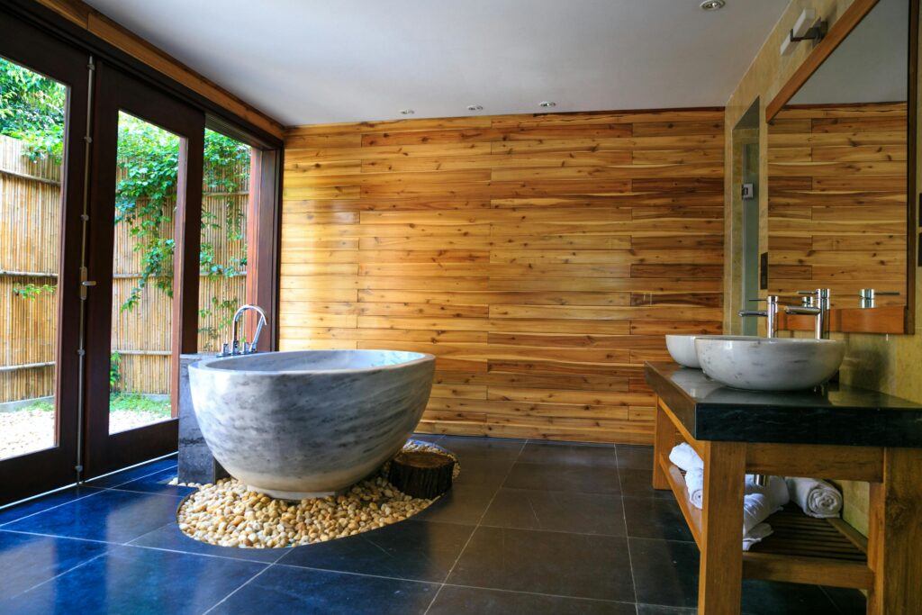 Elegant bathroom showcasing a modern marble tub and wooden interior for a serene escape.